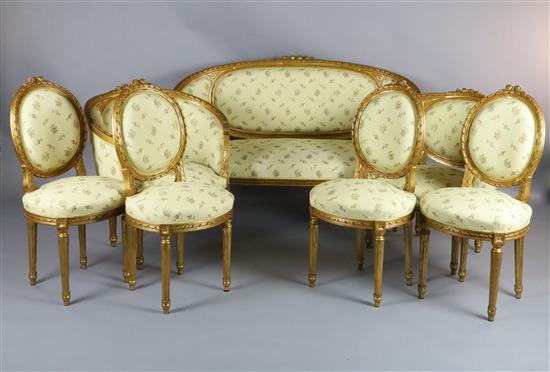 An early 20th century Louis XVI style carved and giltwood seven piece salon suite, settee 4ft 10in.
